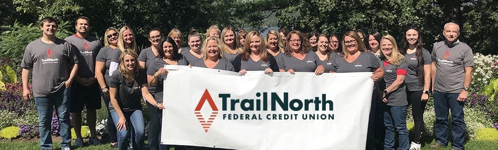 Employees holding TrailNorth banner